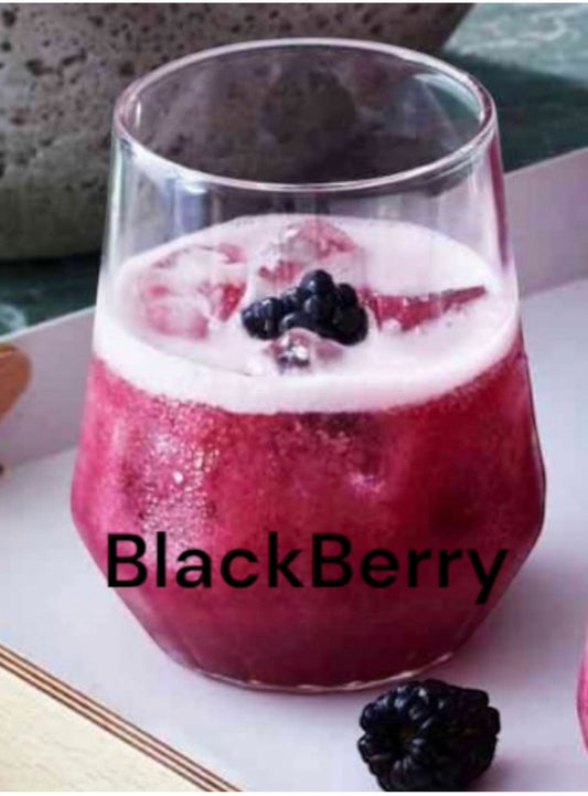 Glass of blackberry drink with ice and berries on a white surface